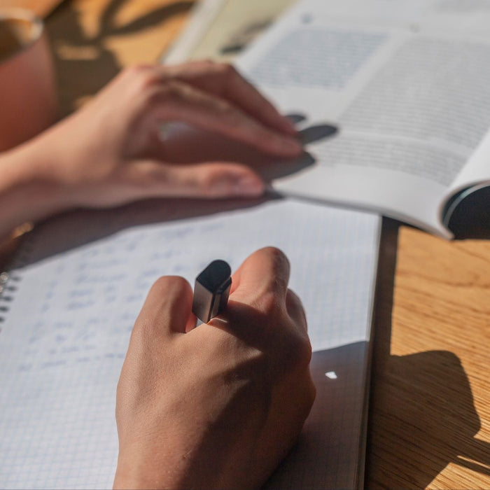 Person writing a social story with pen and paper.